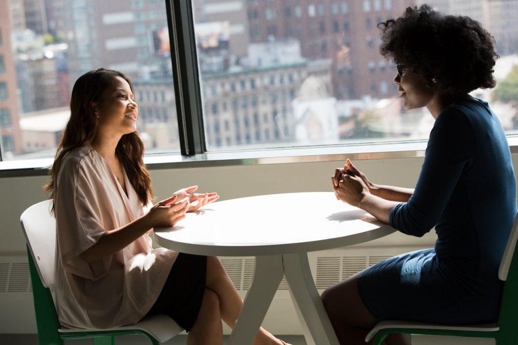 a woman and a man sitting at a table talking