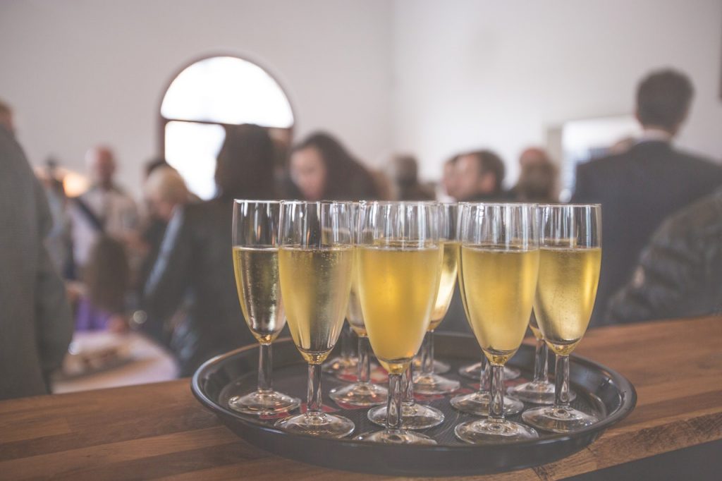 a group of people sitting at a table with glasses of champagne