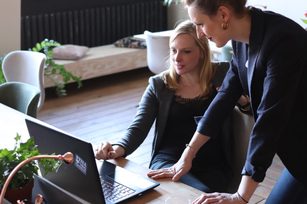 a woman and a man looking at a laptop