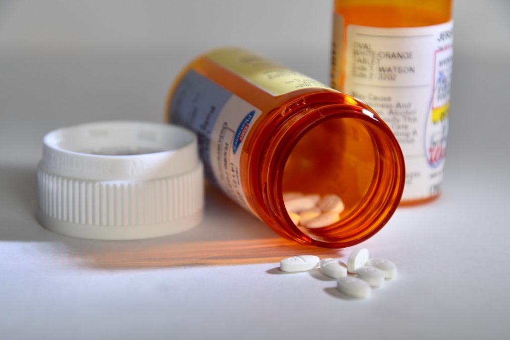 a bottle of pills next to a container of medicine