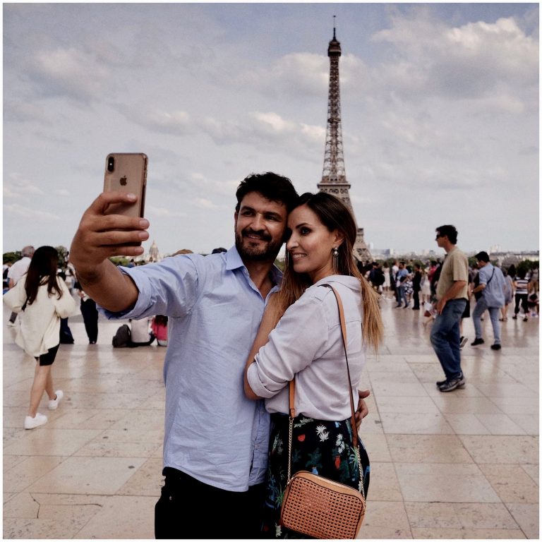 a man taking a selfie with a woman holding a phone