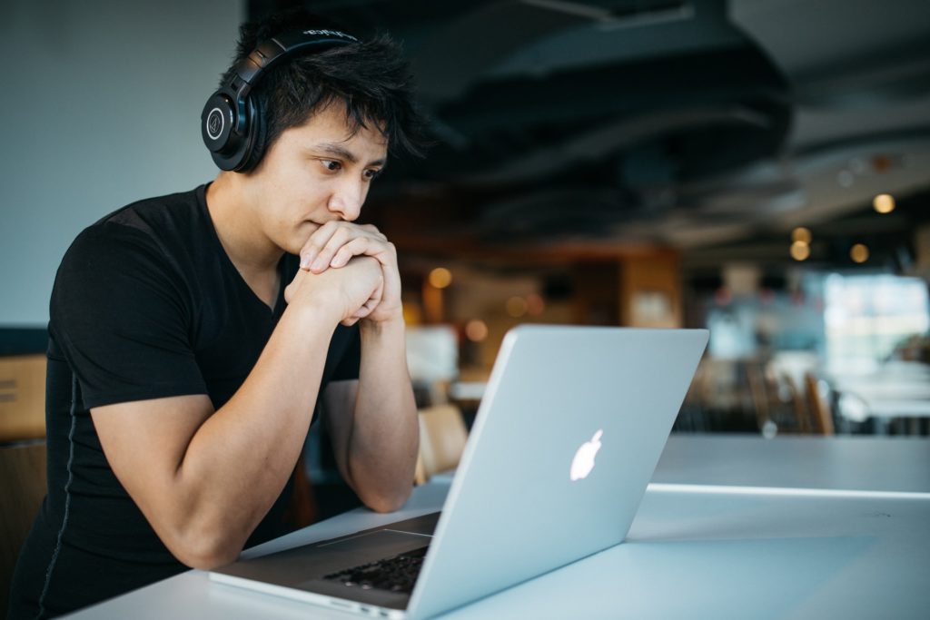 a person with headphones on and a laptop in front of him