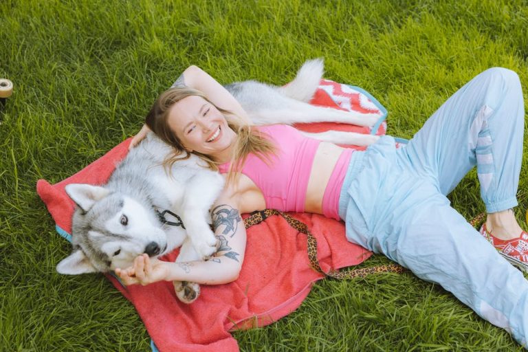 a person lying on the grass with a dog