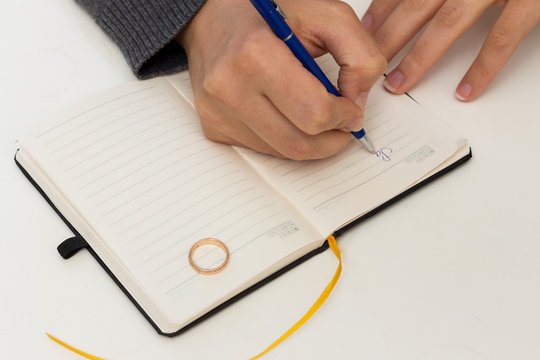 a person writing on a piece of paper